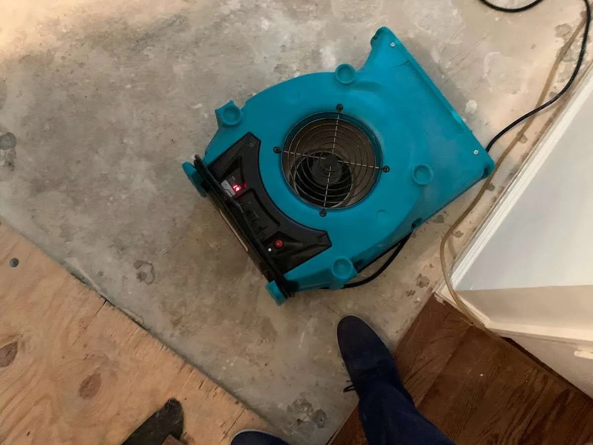 Air mover drying subfloor during Leak Detection & Repair in Milliken